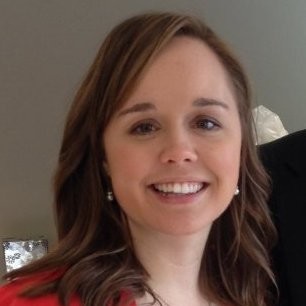 Portrait of a smiling woman with shoulder-length brown hair, wearing a red top.
