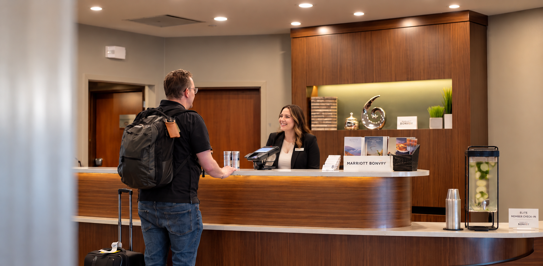 Hotel associate welcoming a guest at the front desk