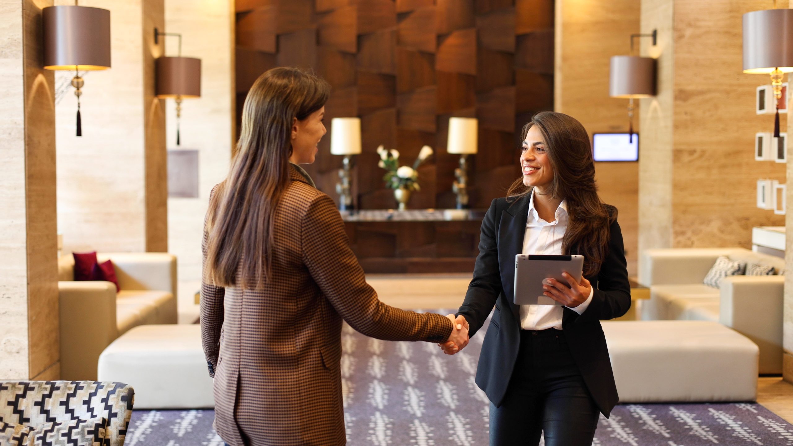 Hospitality professionals shaking hands in a hotel lobby